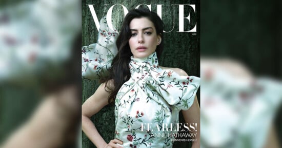 A woman in a floral, high-neck dress poses in front of a dark green backdrop on the cover of Vogue magazine, with the headline "FEARLESS!" and the name Anne Hathaway featured prominently.