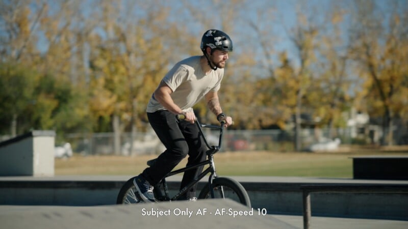 A young man wearing a helmet rides a BMX bike at a skate park, surrounded by trees with autumn foliage. Text at the bottom reads, "Subject Only AF - AF-Speed 10.