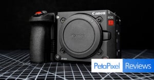 A Canon EOS cinema camera body without a lens is displayed on a grid-patterned surface with the Petapixel Reviews logo in the lower right corner.