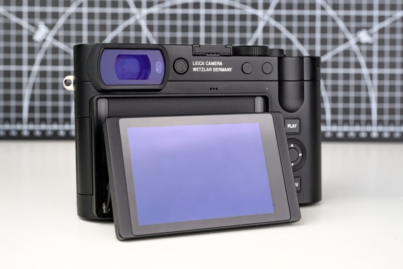 A digital camera with a tilting LCD screen is shown from the back, displaying the brand "Leica Camera Wetzlar Germany." A grid-patterned background is visible behind the camera.
