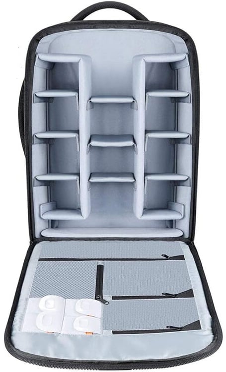 An open camera backpack with multiple padded compartments for organizing camera gear and accessories, featuring mesh zippered pockets on the inner flap.