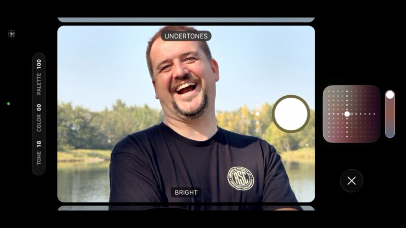 A smiling man with short hair and a beard stands by a lake, wearing a black T-shirt. Camera app interface overlays label him as " UNDERTONES" and "BRIGHT" with photo adjustment controls visible on screen.