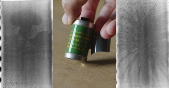 A hand holds a green Kodak film canister on a wooden surface, flanked by two strips of damaged, partially visible black-and-white film negatives.