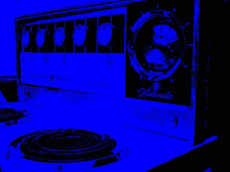 Close-up of a vintage stovetop and oven control panel with round knobs and a large clock face labeled "Automatic." The stovetop burners are visible in the foreground. The image is in high-contrast blue and black.
