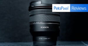 A Rokinon super wide-angle camera lens is displayed upright against a dark background, with the PetaPixel Reviews logo in the top right corner.