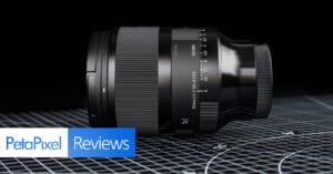 A black Sigma 35mm f/1.2 camera lens lies on its side on a grid-patterned surface. The PetaPixel Reviews logo is displayed in the bottom left corner of the image.