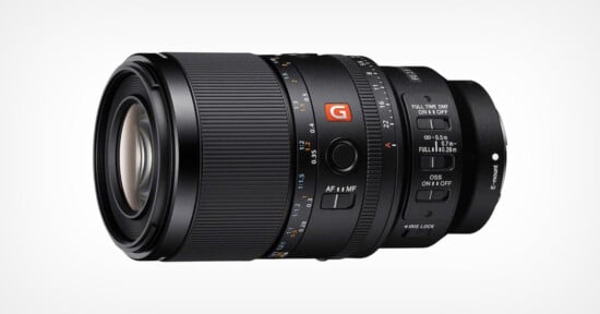 A close-up of a black Sony G Master camera lens with various control switches, focus and zoom rings, and detailed markings, set against a plain white background.