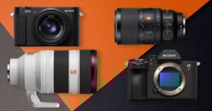 Four Sony camera products on a black and orange background: two cameras (one compact, one mirrorless with no lens) and two interchangeable lenses, including a large telephoto lens and a shorter zoom lens.