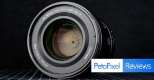 A close-up of a camera lens displaying technical details on the rim, with “Petapixel Reviews” written in blue and white text at the bottom right corner.